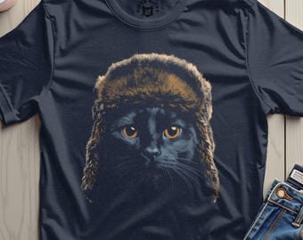 May include: Navy blue t-shirt featuring a black cat wearing a brown fur hat. The cat has yellow eyes and is centered on the shirt. The shirt has a Fifth Kitty logo on the upper back.