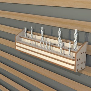 May include: A wooden drill bit organizer with multiple slots for storing drill bits. The organizer is mounted on a wall and has a light wood finish.