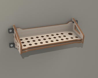 May include: A wooden wall shelf with a grid of holes for storage. The shelf is made of light brown wood with a white finish. It has two metal brackets for mounting on a wall.