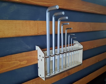 May include: A wooden wall-mounted organizer with a set of silver Allen wrenches. The organizer has slots for each wrench and is designed to keep them organized and easily accessible.