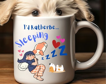 Könnte beinhalten: Eine weiße Keramiktasse mit einem blauen und rosa Design, das ein schlafendes Mädchen und zwei Hunde zeigt. Der Text auf der Tasse lautet "I'd Rather Be... Sleeping" mit einem großen blauen "Z" und kleineren "z"s.