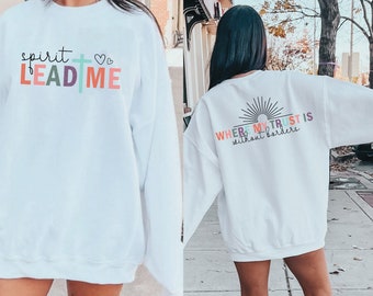 May include: White sweatshirt with a colorful graphic on the front that says "spirit LEAD ME" with a cross and hearts. The back of the sweatshirt has a colorful graphic that says "WHERE MY TRUST IS without borders" with a sun graphic.