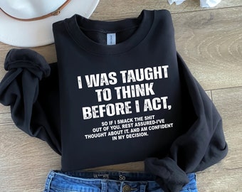 May include: Black sweatshirt with white text that reads "I was taught to think before I act, so if I smack the shit out of you, rest assured-I've thought about it, and am confident in my decision."