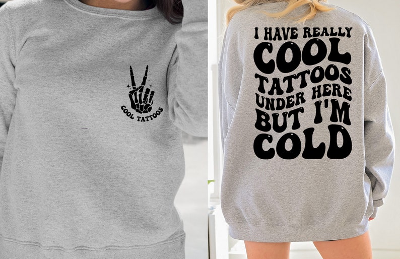May include: Gray sweatshirt with a peace sign skeleton hand graphic on the left side and the text "I have really cool tattoos under here but I'm cold" on the back.