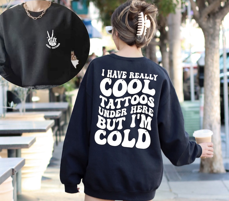 May include: Black sweatshirt with white text that reads "I have really cool tattoos under here but I'm cold".