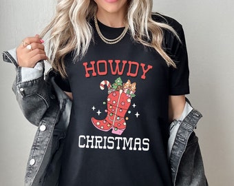 May include: Black t-shirt with a white graphic of a cowboy boot filled with Christmas decorations and the text "Howdy Christmas".