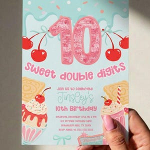 Puede incluir: Una tarjeta de invitación de cumpleaños azul claro con un gran número 10 rosa de lentejuelas, cerezas rojas e ilustraciones de batidos. El texto dice: Sweet double digits, Join us to celebrate Jinsley's 10th Birthday, Saturday, December 13th at 2 PM, 123 Sprinkle Sunshine Lane, Bubblegum Hills, TX 78901, RSVP Alexis at 555-555-5555.