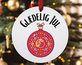 Könnte beinhalten: Runder weißer Anhänger mit dem Text "Gledelig Jul" in schwarzer Schrift. In der Mitte ist ein roter und goldener Weihnachtsanhänger mit geometrischem Muster abgebildet.