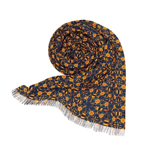 May include: A blue and orange patterned scarf with a fringed edge. The scarf is rolled up and tied in a knot.