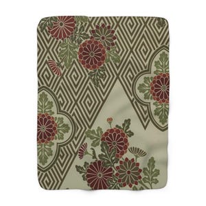 May include: A green and white geometric pattern with red and green floral designs. The pattern features a repeating diamond shape with a floral motif in each corner.