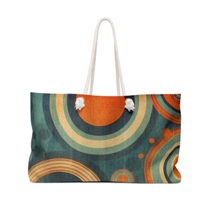 May include: A large, white canvas tote bag with a design of overlapping circles in shades of orange, yellow, blue, and green. The circles have a vintage, faded look.