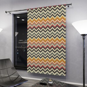 Könnte beinhalten: Ein Vorhang mit einem Chevron-Muster in Orange-, Gelb-, Blau- und Grautönen. Der Vorhang hängt an einer silbernen Gardinenstange.