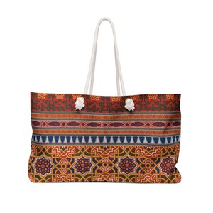 May include: A large red, blue, and yellow tote bag with a white rope handle and a geometric pattern. The pattern features intricate designs and a repeating motif.
