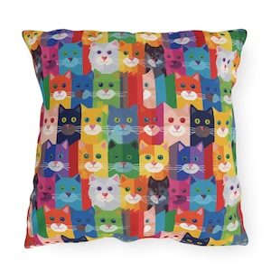 May include: A colourful throw pillow with a repeating pattern of cartoon cats in various colours. The cats are arranged in rows, with each row featuring a different colour.
