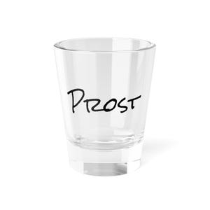 May include: A clear glass shot glass with the word "Prost" written on the side in black marker.