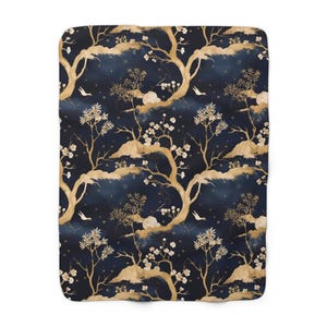 Könnte beinhalten: Eine marineblaue Fleece-Decke mit einem goldenen Blumenmuster. Das Muster zeigt stilisierte Bäume, Blumen und Vögel.
