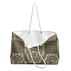 Pode incluir: Uma grande bolsa tote de lona branca com alças de corda marrom. A bolsa tem um padrão geométrico com um esquema de cores marrom e bege.