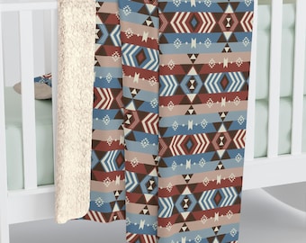 May include: A soft, plush throw blanket with a geometric pattern in shades of blue, red, and brown. The blanket has a white sherpa backing.