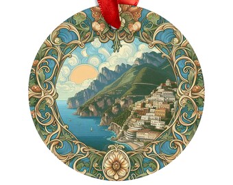 May include: A round metal ornament with a detailed illustration of a coastal town nestled in a mountainside. The town is surrounded by a blue ocean and a bright sun shines in the sky. The ornament is decorated with a gold and green floral design.