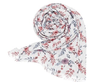 May include: White scarf with a floral pattern featuring pink and purple flowers and leaves. The scarf has a fringed edge.