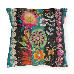 May include: A colorful throw pillow with a floral pattern. The pillow features a variety of flowers in shades of pink, yellow, orange, and green, set against a black background with turquoise stripes.