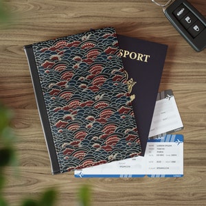 May include: A passport holder with a blue and red floral pattern. The holder is closed and sitting on a wooden surface with a passport and two airline boarding passes.