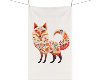 Puede incluir: Una toalla de cocina blanca con una ilustración colorida de un zorro. El zorro está decorado con patrones florales en tonos naranja, rojo, azul y verde.