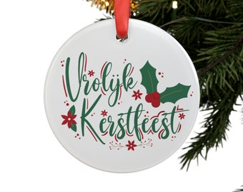 Könnte beinhalten: Weißer Keramik-Weihnachtsbaumschmuck mit rotem und grünem Weihnachtsgrün und dem Text "Vrolijk Kerstfeest" in Rot und Grün.