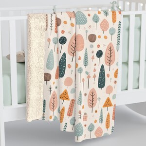 May include: A soft, plush throw blanket with a white background and a repeating pattern of colorful trees. The blanket has a cream-colored sherpa lining.