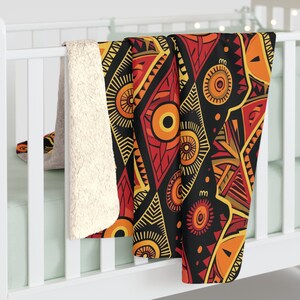 May include: A soft, plush throw blanket with a geometric pattern in shades of red, orange, yellow, and black. The blanket is made of a soft, fuzzy material and is perfect for cuddling up on the couch.