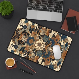 Pode incluir: Um tapete de rato colorido com um design floral e geométrico em tons de azul, dourado e branco. O tapete de rato apresenta um padrão de inspiração japonesa tradicional.