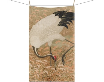 May include: A white crane with black wing feathers and a red head is depicted in a field of tall grass. The crane is looking down at the ground, its long neck bent. The background is a soft brown colour.