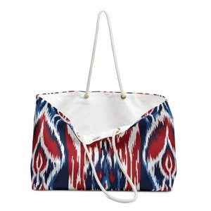 May include: A white canvas tote bag with red, blue, and white ikat pattern. The bag has white rope handles.