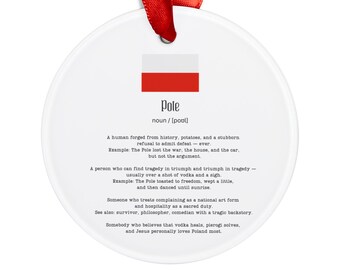 May include: A white, circular ceramic decoration with a red ribbon. It displays the Polish flag and the word "Pole" with a definition. The text describes a Pole's characteristics and cultural references.