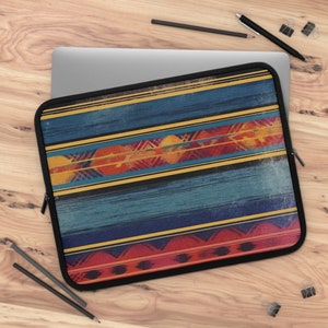 May include: A laptop sleeve with a colorful geometric pattern. The pattern features stripes of blue, yellow, red, and orange. The sleeve has a zipper closure.