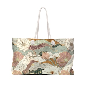 May include: A white canvas tote bag with a floral design. The bag features a pattern of pink, white, and gold flowers on a light blue and green background. The bag has white rope handles.