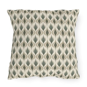 May include: A decorative throw pillow with a geometric pattern in shades of green, brown, and beige. The pattern features a series of overlapping teardrop shapes.