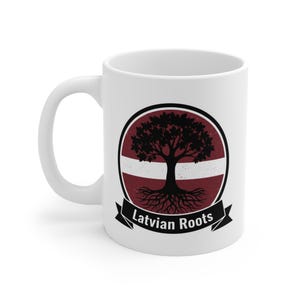 May include: White ceramic mug featuring a design with a tree silhouette, roots, and the text "Latvian Roots." The design is set against a burgundy and white background, with a black border and banner.