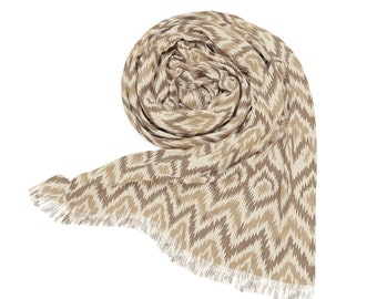 May include: A beige and brown patterned scarf with a fringed edge. The scarf is rolled up and tied in a knot.