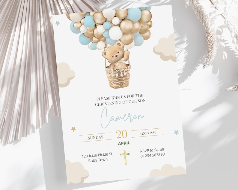 Może przedstawiać: Zaproszenie na baby shower z pluszowym misiem w balonie na gorące powietrze wykonanym z niebieskich i złotych balon&oacute;w. Zaproszenie brzmi: "Proszę dołączyć do nas na chrzciny naszego syna Camerona, w niedzielę, 20 kwietnia, o godzinie 11:00, 123 Ickle Pickle St, Baby Town, RSVP do Sarah 01234 567890".