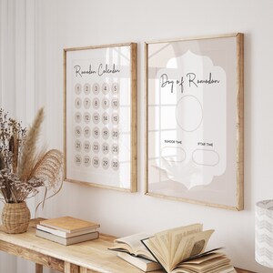 May include: Two framed prints with a beige background. The print on the left is a Ramadan calendar with the numbers 1 through 30 in circles. The print on the right has the text "Day of Ramadan" and two blank circles for "Suhoor Time" and "Iftar Time".