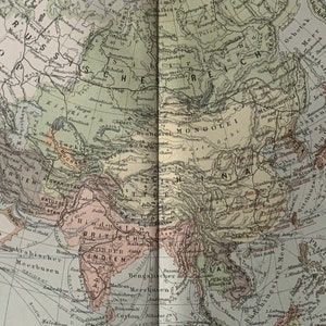 Könnte beinhalten: Eine Vintage-Karte von Asien mit detaillierten Grenzen und geografischen Merkmalen. Die Karte zeigt Länder wie Russland, China, Indien, Japan und die Mongolei. Die Karte ist in Grün-, Braun- und Rottönen gedruckt.