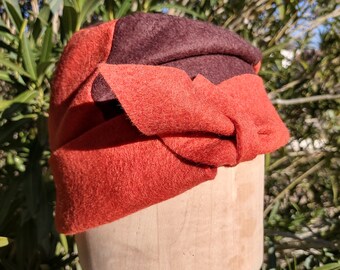 May include: A brown and orange felt headband with a knotted bow on top.