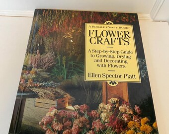 May include: A hardcover book titled "Flower Crafts" by Ellen Spector Platt. The cover features a vibrant floral arrangement with a woven basket. The book is a step-by-step guide to growing, drying, and decorating with flowers.