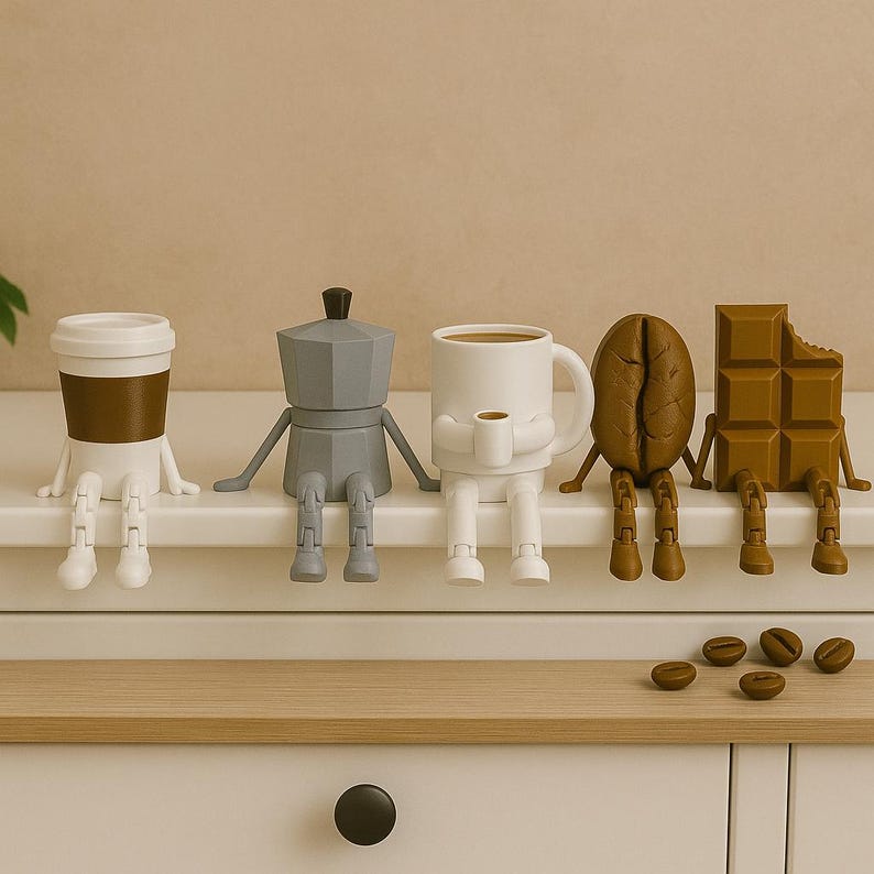 May include: A collection of whimsical coffee-themed figurines, including a to-go cup, a stovetop espresso maker, a coffee mug, a coffee bean, and a chocolate bar. Each figure has arms and legs, and they are sitting on a white surface. Several coffee beans are scattered below.