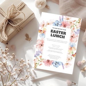 Op de afbeelding: Een witte uitnodigingskaart met een bloemige rand. De tekst luidt "U bent uitgenodigd voor een paaslunch" met de datum en tijd van het evenement. De uitnodiging is versierd met aquarelbloemen in tinten roze, blauw en paars.