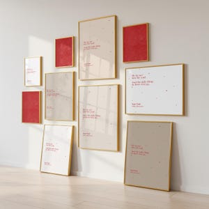 Könnte beinhalten: Eine Sammlung gerahmter Kunstdrucke in verschiedenen Größen und Farben, darunter Rot und Beige. Jeder Druck zeigt ein Zitat im minimalistischen Stil mit einem goldenen Rahmen. Die Drucke sind an einer weißen Wand angeordnet.