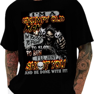 May include: Black t-shirt with a graphic featuring a skull holding two guns, flames, and the text "I'M A GRUMPY OLD MAN, I'M TOO OLD TO FIGHT, TO SLOW TO RUN, I'LL JUST SHOOT YOU AND BE DONE WITH IT!"