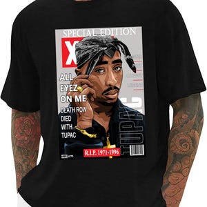 以下が含まれることがあります： Tupac Shakurの雑誌風グラフィックが特徴の黒いTシャツ。「SPECIAL EDITION」、「ALL EYEZ ON ME」、「R.I.P. 1971-1996」の文字が含まれています。バンダナと金のジュエリーを身につけたTupacが描かれています。