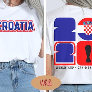 May include: White t-shirt with the word "CROATIA" in blue and red lettering. The back of the shirt features the number "26" in blue and red, with the Croatian flag and the text "WORLD CUP CAN MEX USA".